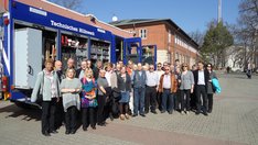 Ein neues THW-Einsatzfahrzeug als Hintergrund für das Gruppenbild in der Zentrale des THW